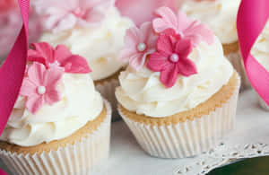 Delicious Pink Cupcakes With Whipped Cream And Cherry On Top Wallpaper