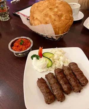 Delightful Dish Of Ćevapi Sausages And Fresh Pita Bread Wallpaper