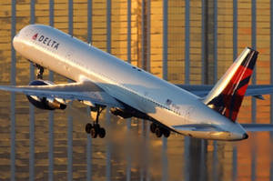 Delta Airlines Airplane Flying By Building Facade Wallpaper