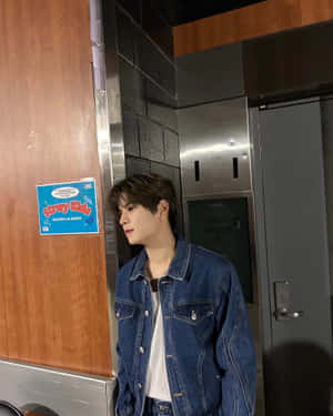 Denim Clad Young Man Near Dressing Room Wallpaper