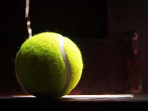 Description- Tennis Ball Flying In A Slow-motion, Blurred Background - Representing A Victorious Moment. Wallpaper