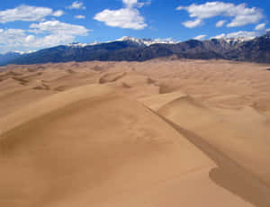 Desert_ Dunes_with_ Mountain_ Backdrop Wallpaper