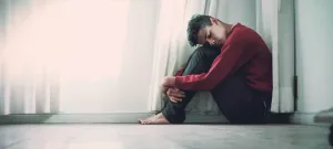 Despondent Individual Seatedon Floor Wallpaper