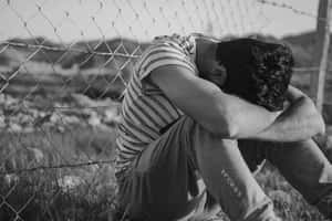 Despondent Man Behind Fence Wallpaper