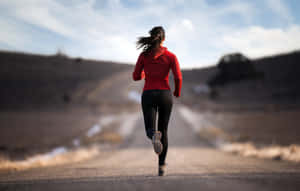 Determined Female Athlete Training For Marathon Wallpaper