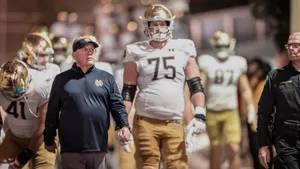 Determined Football Coach Analyzing Game Strategy Wallpaper