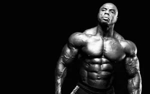 Determined Man Displaying Body Muscles Wallpaper