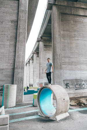 Determined Young Man Embracing His Courage In A Concrete Jungle Wallpaper