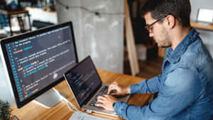 Developer Writing Code In Front Of A 1920x1080 Hd Monitor Wallpaper