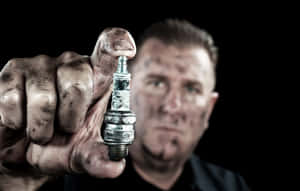 Dirty Man Holding Spark Plug Wallpaper
