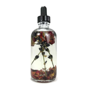 Divine Rose Oil In A Luxurious Bottle Wallpaper