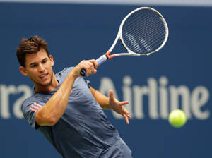 Dominic Thiem In Action On The Tennis Court Wallpaper