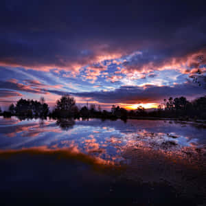 Dramatic Sunset Over Serene Waters Wallpaper