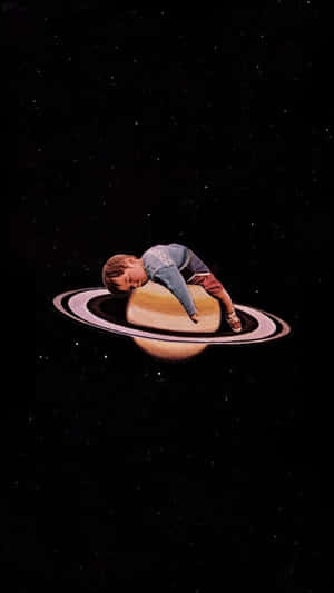 Dreamy Space Child Restingon Saturn Ring Wallpaper