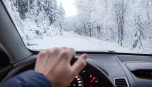 Driving On A Snowy Road In Winter Wallpaper
