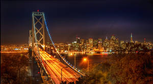 Dusk Descending Over San Francisco Skyline Illuminated By Vibrant Orange Hues Wallpaper