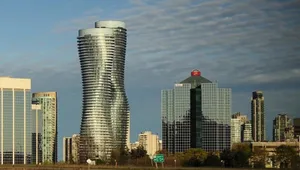 Dusk Falls Over The Bustling Cityscape Of Mississauga With Illuminated Skyscrapers Mirrored On The Lake's Surface Wallpaper