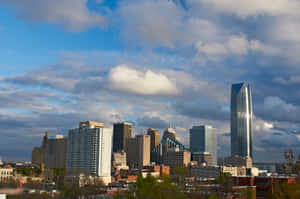 Dynamic_ City_ Skyline_ Under_ Cloudy_ Skies.jpg Wallpaper