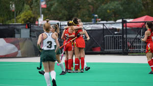 Dynamic Field Hockey Girls Team In Action Wallpaper