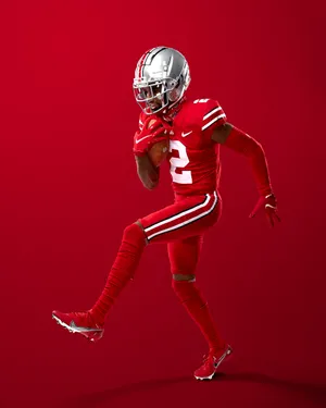 Dynamic Football Player Red Backdrop Wallpaper
