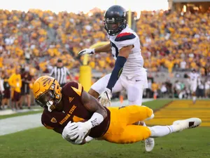 Dynamic Wide Receiver Catching Football In Mid-air Wallpaper