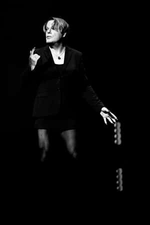 Eddie Izzard Striking A Pose On Stage Wallpaper