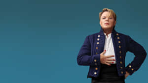 Eddie Izzard Striking A Pose On Stage Wallpaper