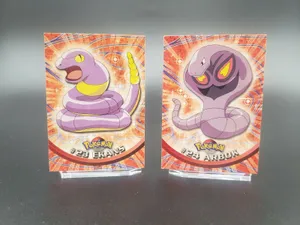 Ekans And Arbok Cards On Blurry Gray Background Wallpaper