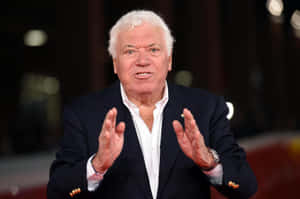 Elderly Gentleman Gesturing During Event Wallpaper