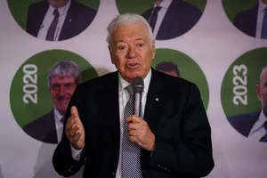 Elderly Gentleman Speakingat Event Wallpaper