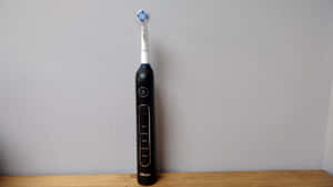 Electric Toothbrush Standing Against Wall Wallpaper