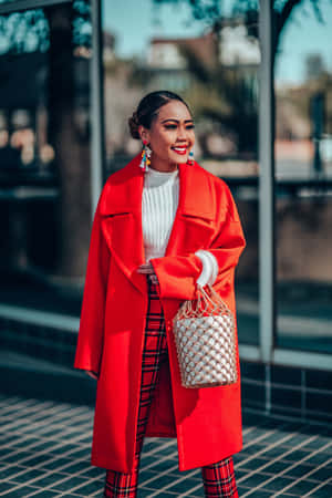 Elegance In Red - Chic Woman Wearing A Stylish Red Coat Wallpaper