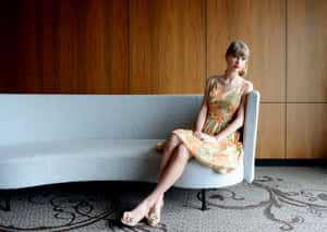 Elegant Celebrity Sittingon Couch Wallpaper