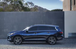 Elegant Infiniti Qx60 Driving On A Picturesque Road Wallpaper