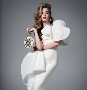 Elegant Modelin White Dresswith Designer Bag Wallpaper
