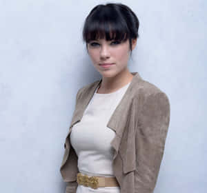 Elegant Portraitof Womanin Beige Outfit Wallpaper