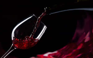 Elegant Red Wine Glass Filled With Fine Wine Wallpaper