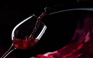 Elegant Red Wine Glass Filled With Fine Wine Wallpaper