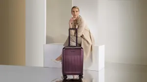 Elegant Travelerwith Purple Suitcase Wallpaper