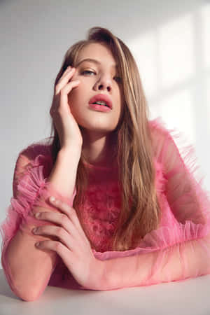 Elegant Woman In Pink Dress Posing In A Luxurious Setting Wallpaper