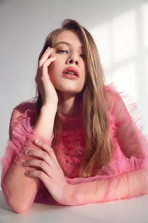 Elegant Woman In Pink Dress Posing In A Luxurious Setting Wallpaper