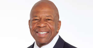 Elijah Cummings Smiling With Simple White Backdrop Wallpaper