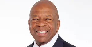 Elijah Cummings Smiling With Simple White Backdrop Wallpaper