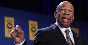 Elijah Cummings Speaking In Front Of Blue Backdrop Wallpaper