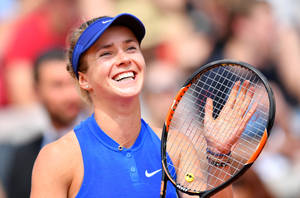 Elina Svitolina Holding A Tennis Racket With A Smile Wallpaper