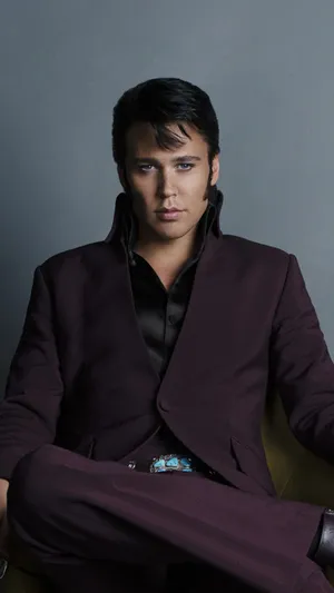 Elvis Presley In His Iconic Getup Of Decorative Military Jacket And Glasses. Wallpaper