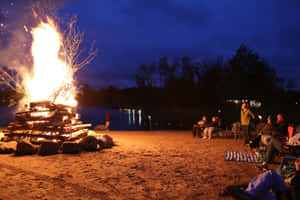 Enchanting Beach Bonfire At Sunset Wallpaper