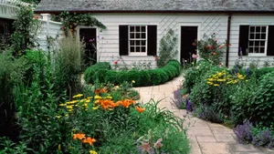 Enchanting Cottage Garden With Colorful Blooms And Stone Pathway Wallpaper