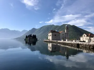 Enchanting View Of Our Lady Of The Rocks Amidst Majestic Mountains Wallpaper
