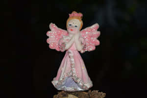 Endearing Angel Figurine With Delicate Pink Wings Wallpaper